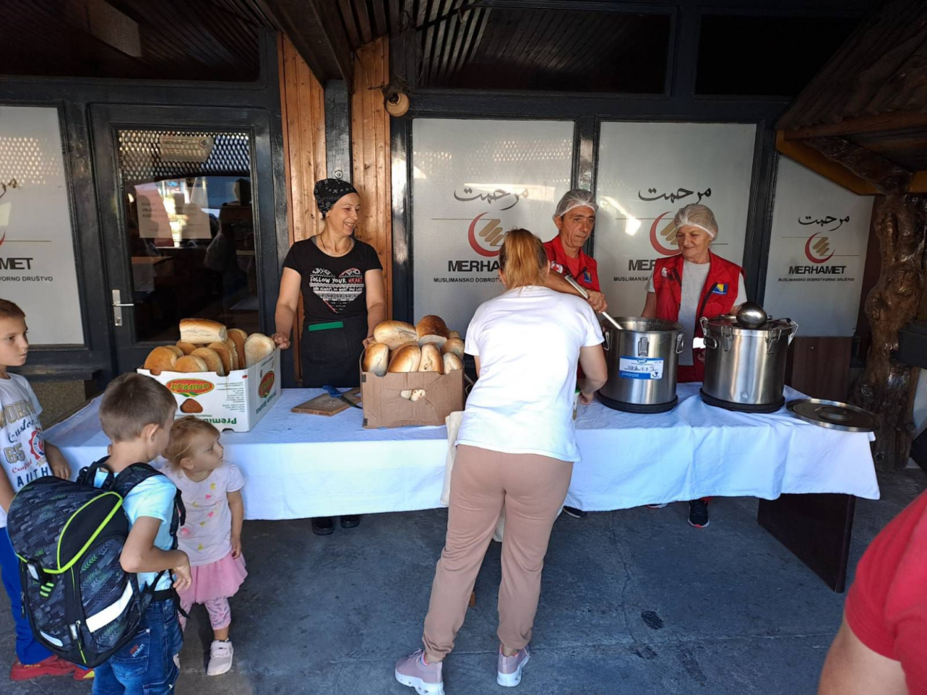 An einem Stand werden warme Mahlzeiten und Brot ausgegeben.
